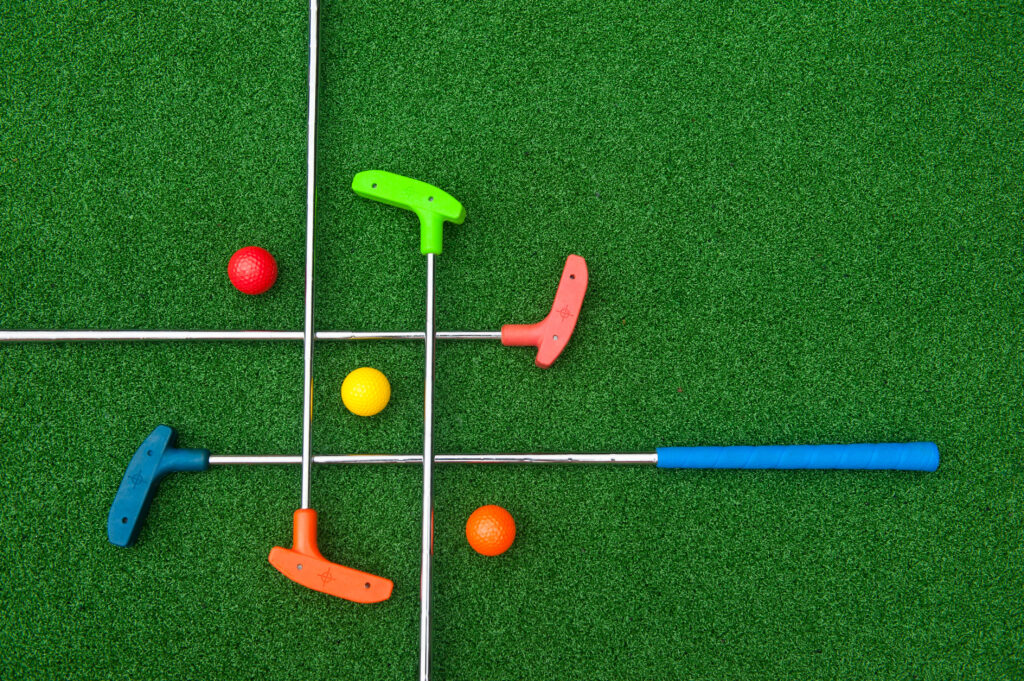 Synthetic grass with golf clubs and balls by Sports Turf in Dalton Georgia.