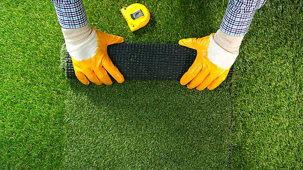 Synthetic turf installation with artificial grass being secured in place