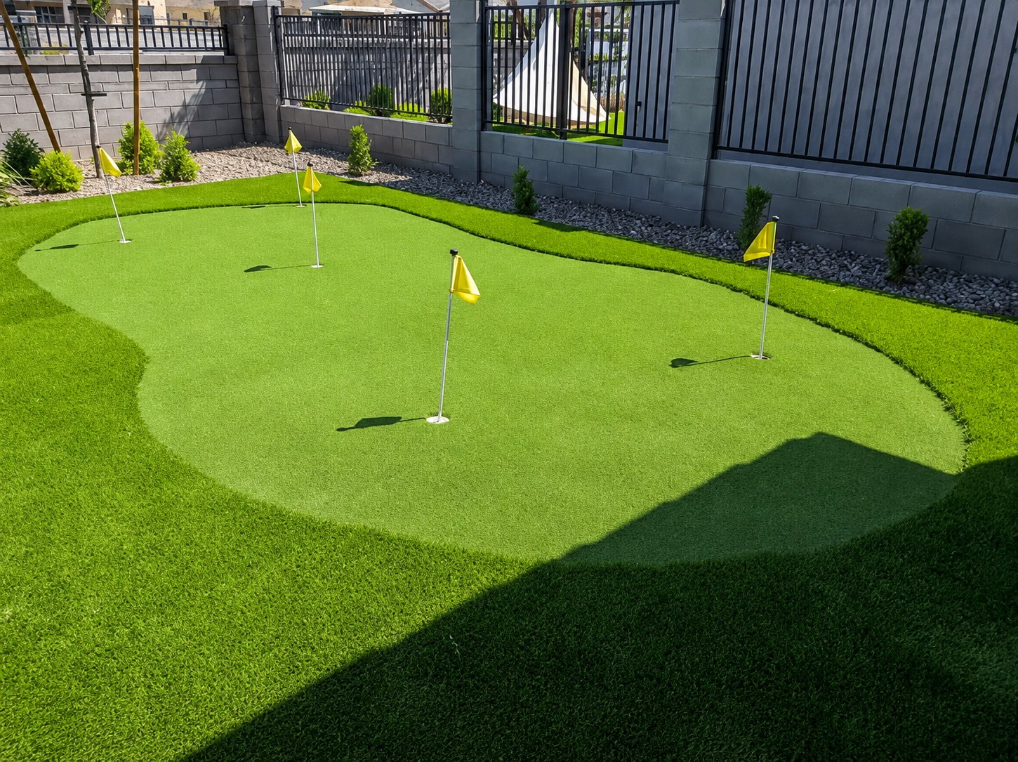 Backyard golf chipping area with synthetic turf and putting holes